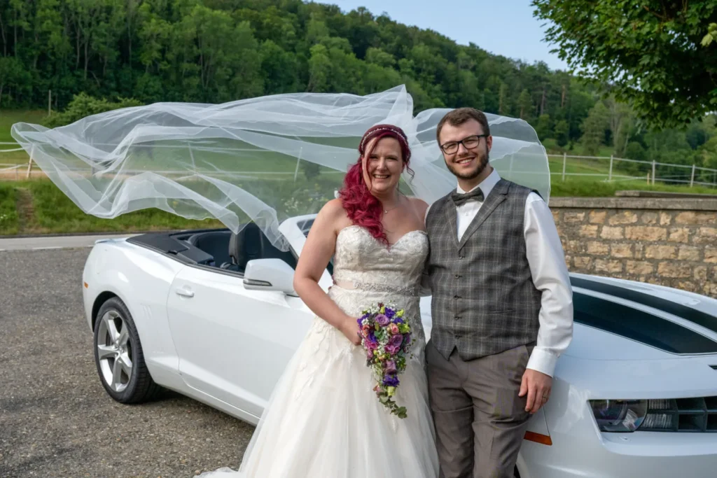 Brautpaar fotografiert vor einem Auto vom Hochzeitsfotograf Bern